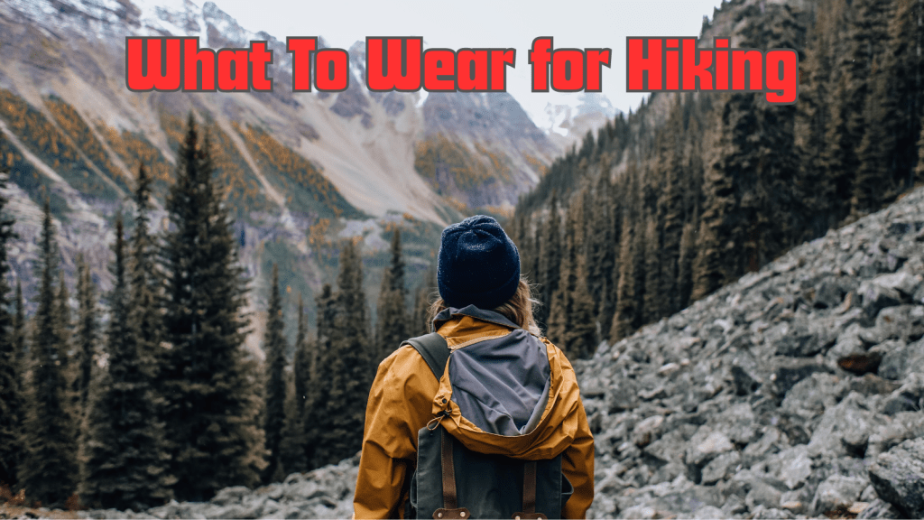 image of a woman with a yellow jacket and backpack hiking in the mountains with the caption saying what to wear for hiking