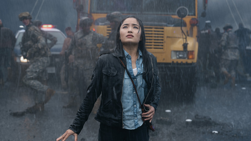 Anna Sawai in front of bus and soldiers, image from Monarch series on Apple TV